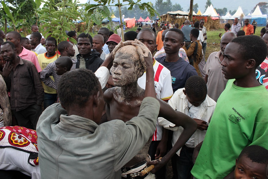 Gidudu gets smeared with thick millet yeast paste on the first day of the three day Imbalu rituals