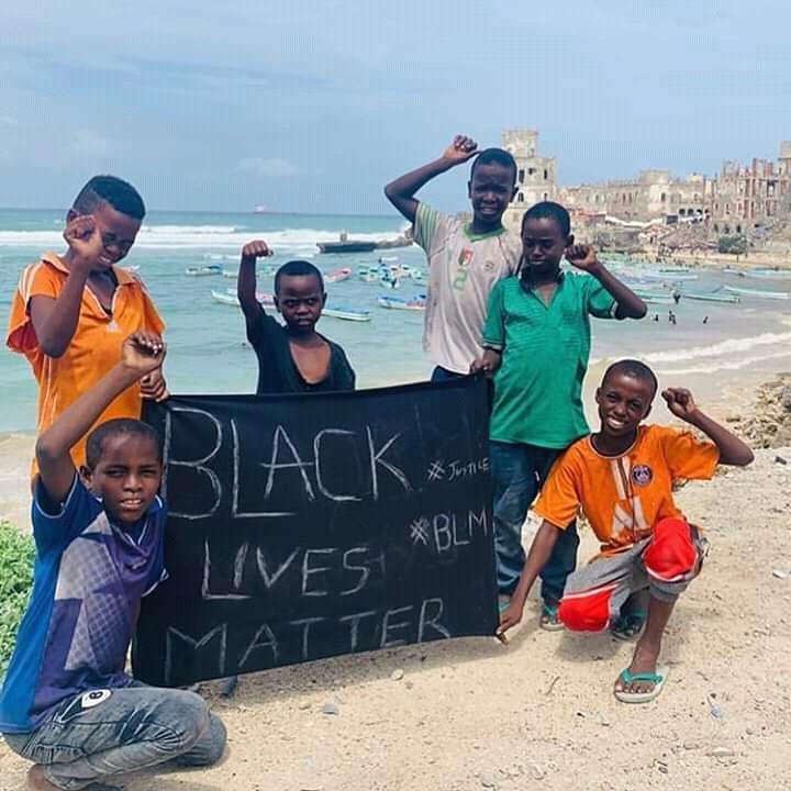 Somali children holding a cloth emblazoned with the words- Black Lives Matter 