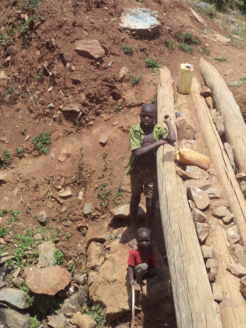 Children lining up to fetch water at a water source in Bunanyuma.111
